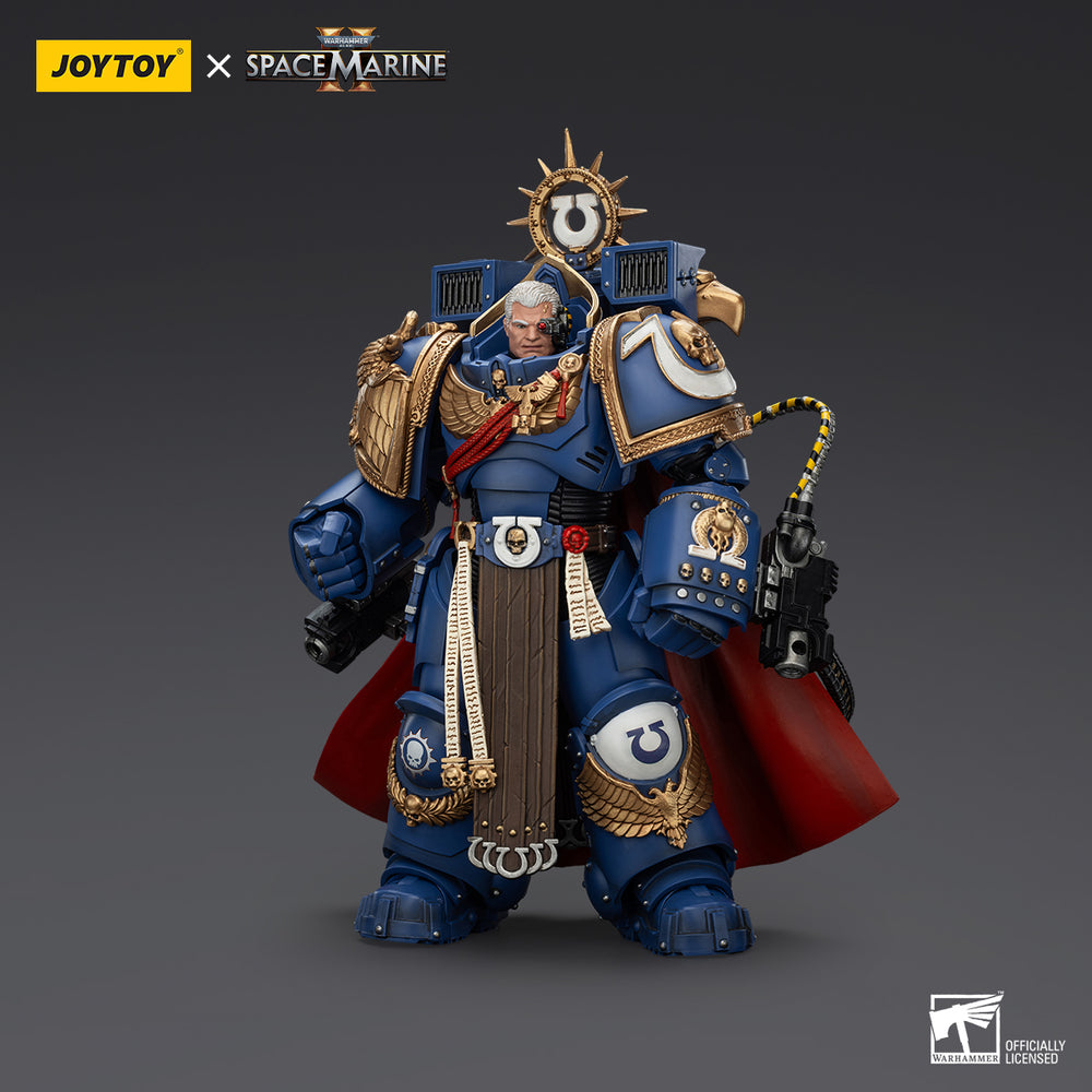 A Joytoy Warhammer 40k Ultramarine Space Marine action figure in blue/gold armor, red cape, bionic eye, holding a weapon