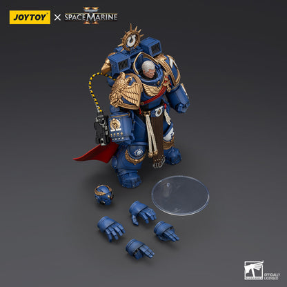 A detailed JoyToy x Space Marine collectible figure in blue and gold armor, with an extra helmet and hands, on a dark surface
