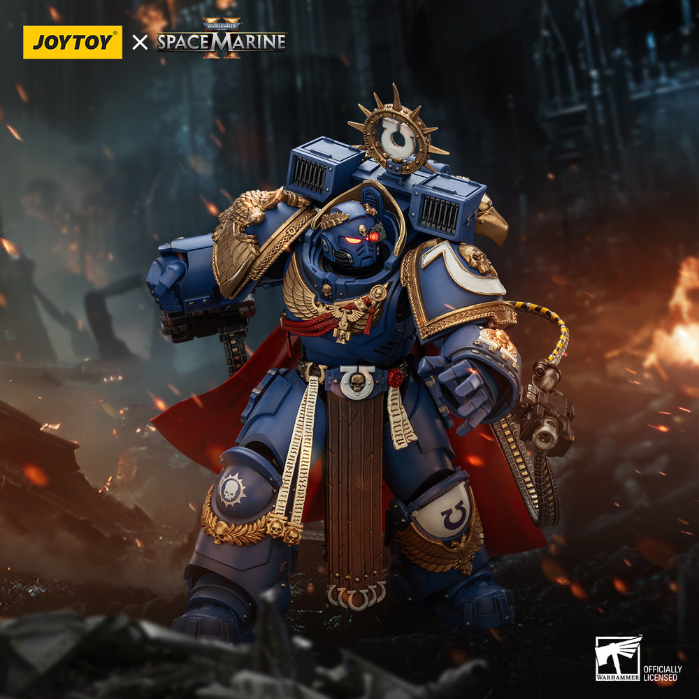 A detailed Ultramarine Captain figure in blue power armor, gold trim, and red cape, stands heroically in a fiery, war-torn ruin
