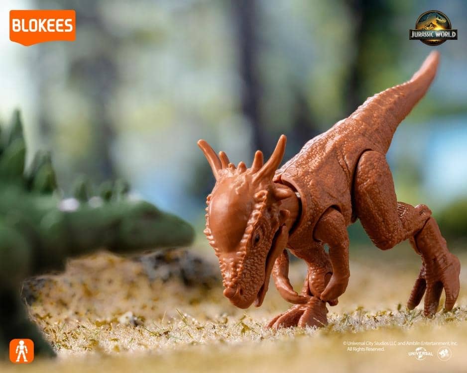 Brown Blokees Jurassic World dinosaur toy crouching low on miniature grass