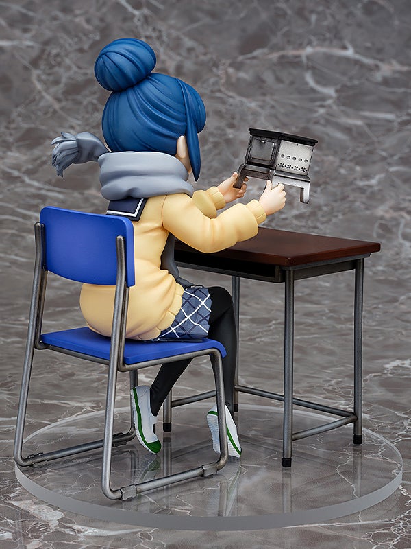 Anime figurine of a blue-haired character in yellow coat and plaid skirt sitting at a desk holding a miniature stove