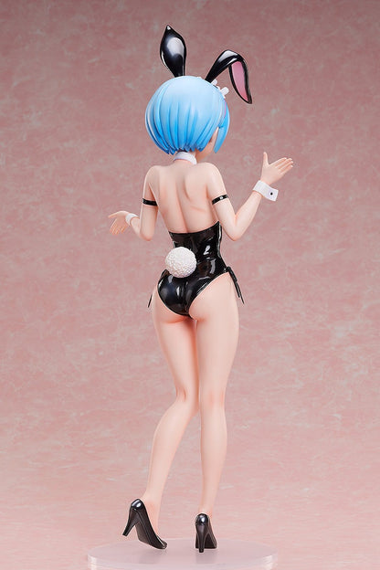 Rear view of a blue-haired anime figurine in a black bunny suit, with ears, a fluffy tail, and high heels, arms raised