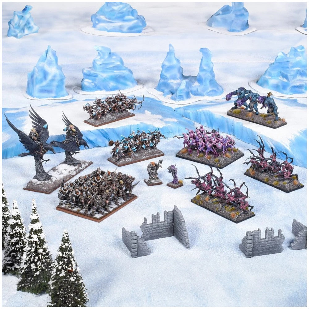 Wargame miniatures: diverse armies and monsters arranged on an icy, snowy battlefield with terrain features