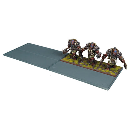 Three armored fantasy wargaming miniatures with weapons, on a grey movement tray