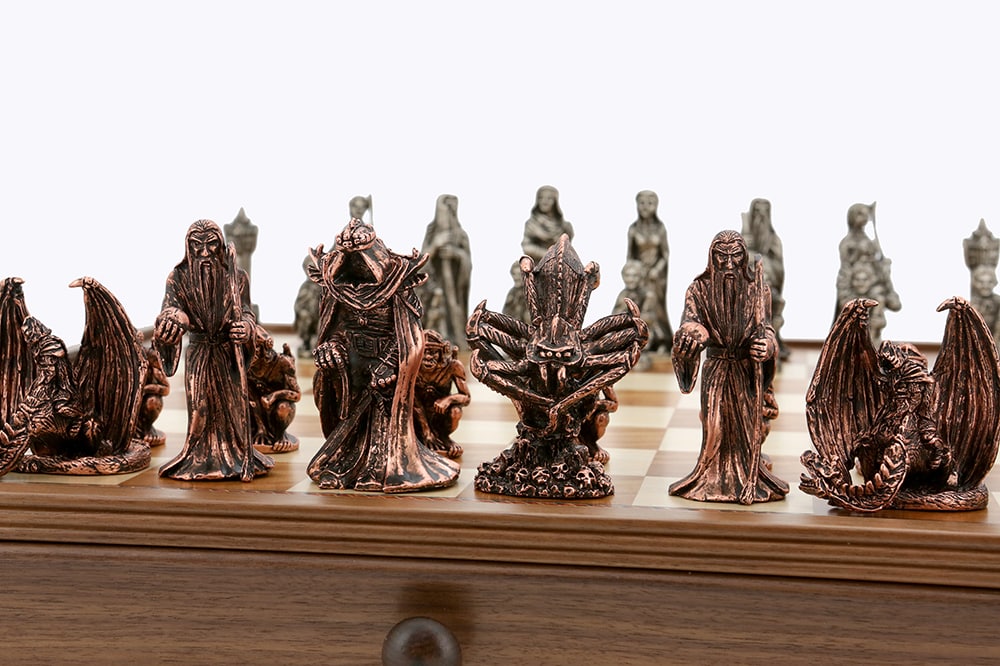 Dark metallic Dal Rossi Evil Ring Metal Chessmen arranged on a light and dark wooden chessboard with a drawer visible below