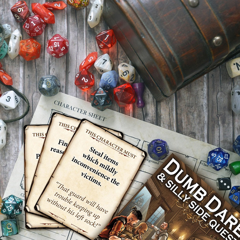 TTRPG setup featuring scattered dice, character sheets, a treasure chest, and "Dumb Dare & Silly Side Quests" cards