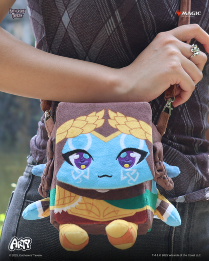 Person carrying a plush character deck box crossbody bag shaped like the blue-skinned chibi character Arty