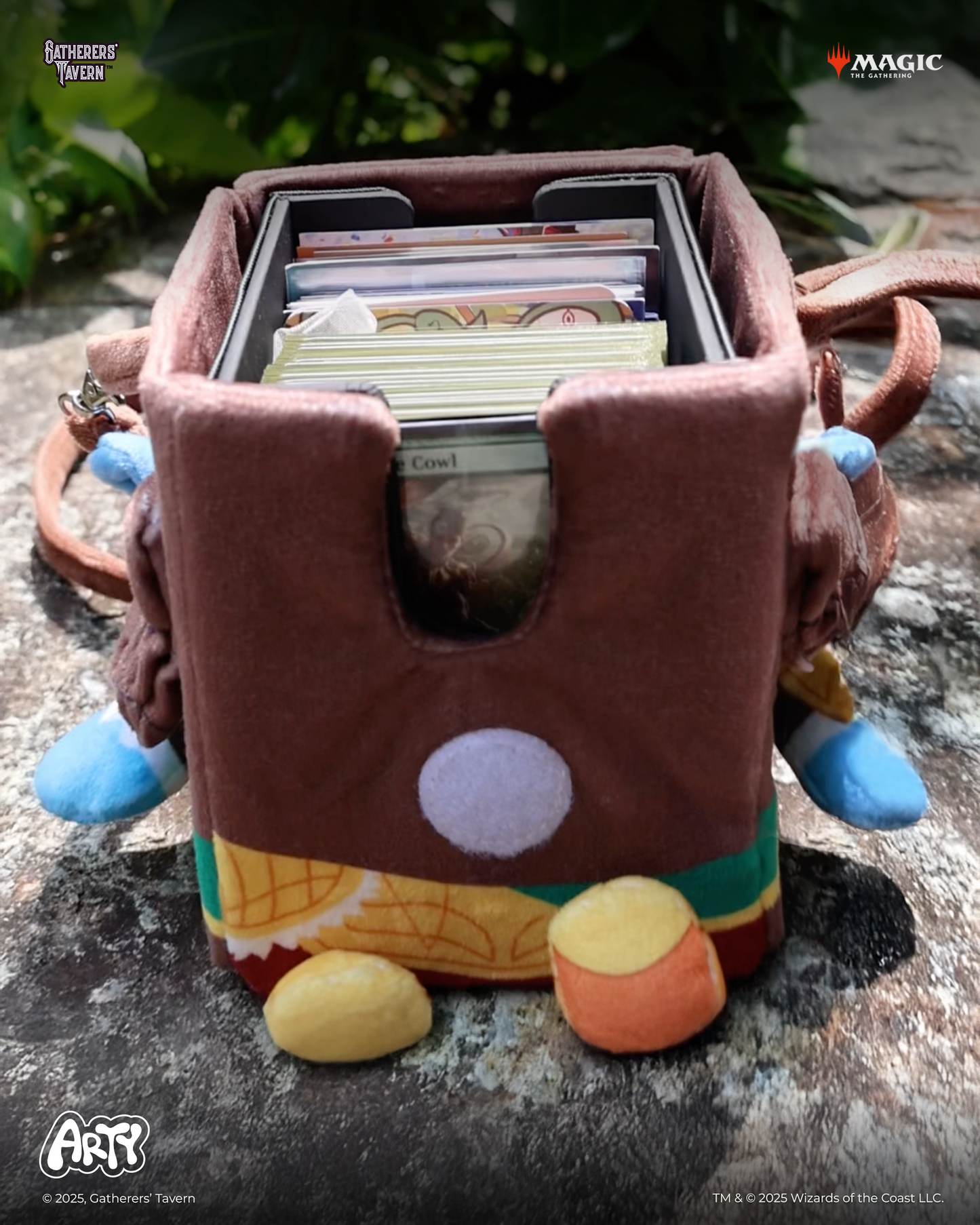 Plush character deck box filled with MTG cards, resting on a stone surface outdoors