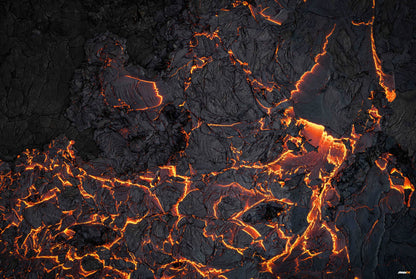 Dark, cracked volcanic rock with glowing orange lava flowing through the fissures