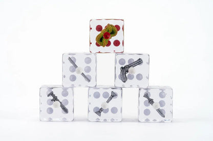 Clear dice stacked in a pyramid. Top die shows green foliage with red dots; others contain miniature Clue game weapons
