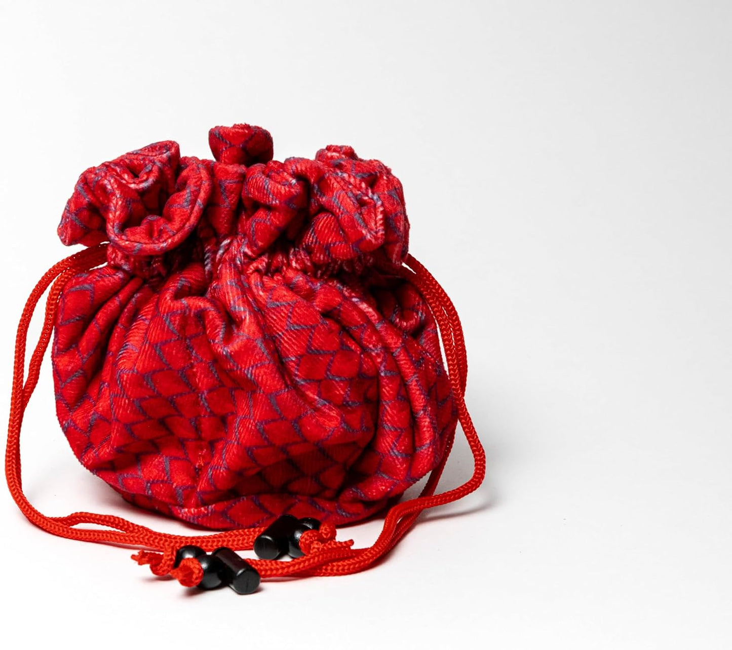 A textured red drawstring pouch with a subtle blue grid pattern, cinched closed, with black cord toggles
