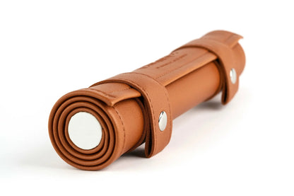 A brown leather roll with two straps and silver snaps on a white background
