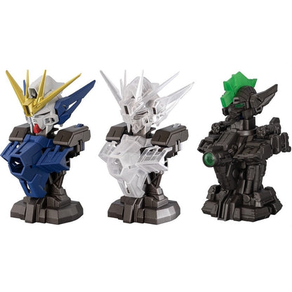 Three Gundam-style robot busts: one blue/gold, one clear plastic, and one dark grey with a green crest