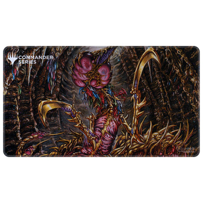 MTG Commander Series playmat: Grotesque Phyrexian creature with a pink head, golden scythes, crouching in a dark, organic cavern