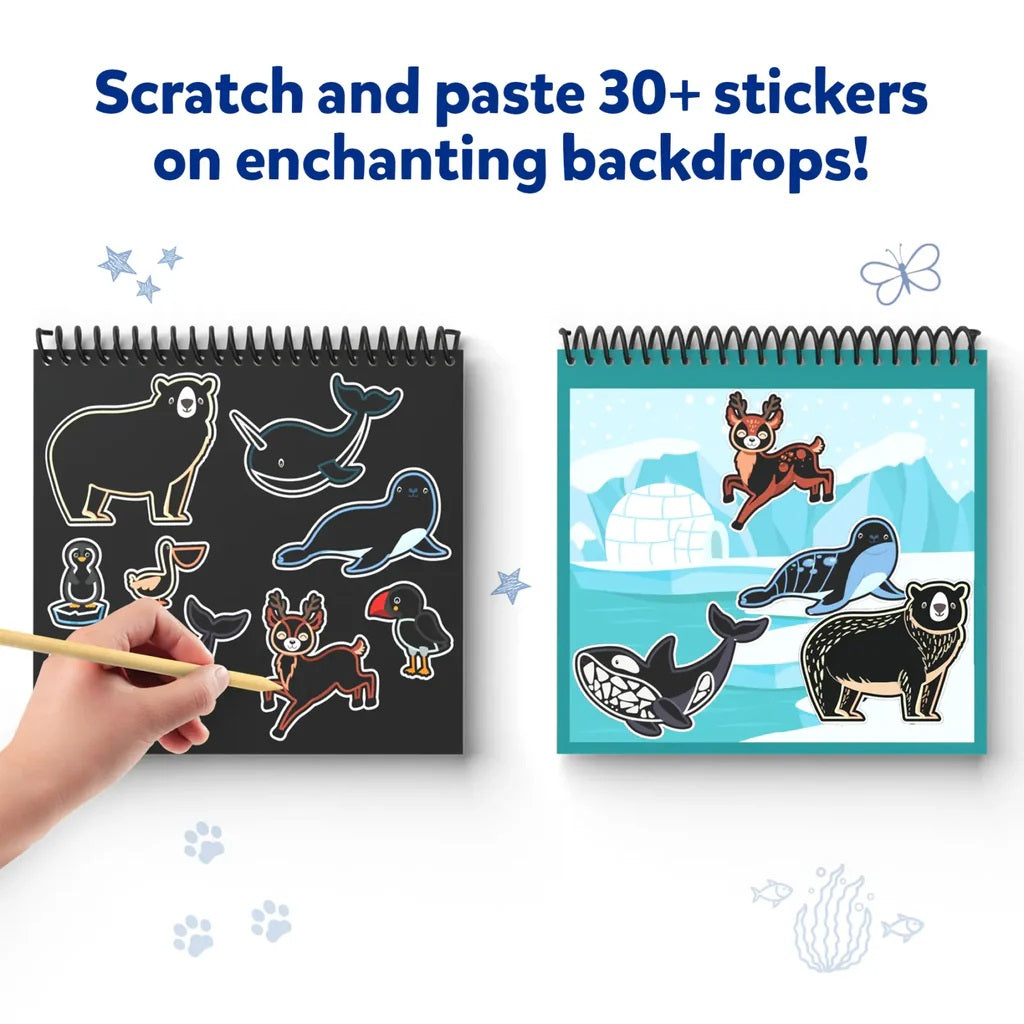 Hand scratches arctic animal stickers from a black pad and pastes them onto an iceberg scene