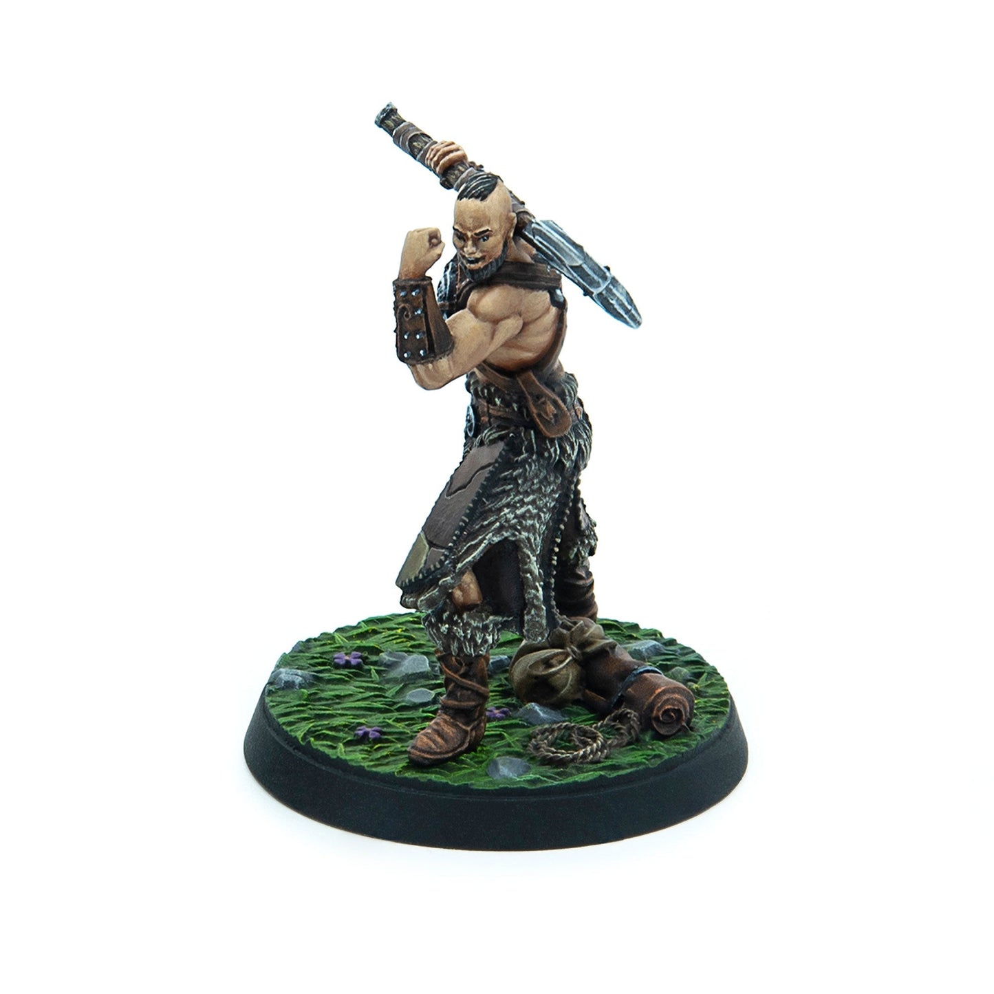 Painted miniature of a muscular barbarian with shaved head and beard, flexing his arm and holding a large weapon over his shoulder
