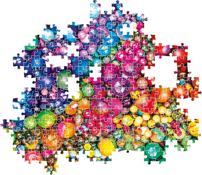 Partially completed jigsaw puzzle showing a vibrant pile of colorful, sparkling ornaments