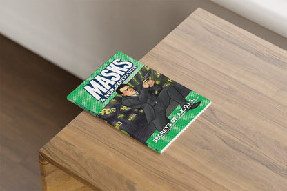 Green 'MASKS A NEW GENERATION: SECRETS OF A.E.G.I.S.' book on a wood table. Cover shows a man in a suit aiming a gun.