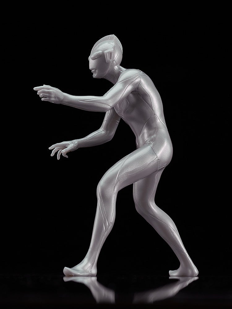 Silver plastic figurine of an alien humanoid in a dynamic pose with one arm extended forward