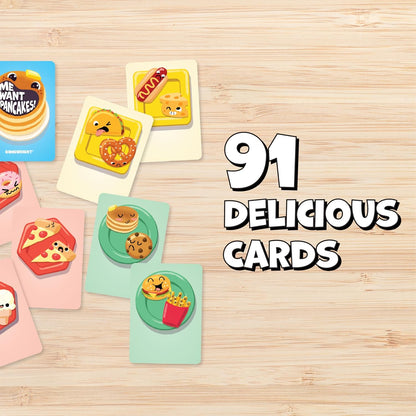 Gamewright game cards with cartoon food, including pancakes and pizza, spread on a wooden table. Text: 91 DELICIOUS CARDS