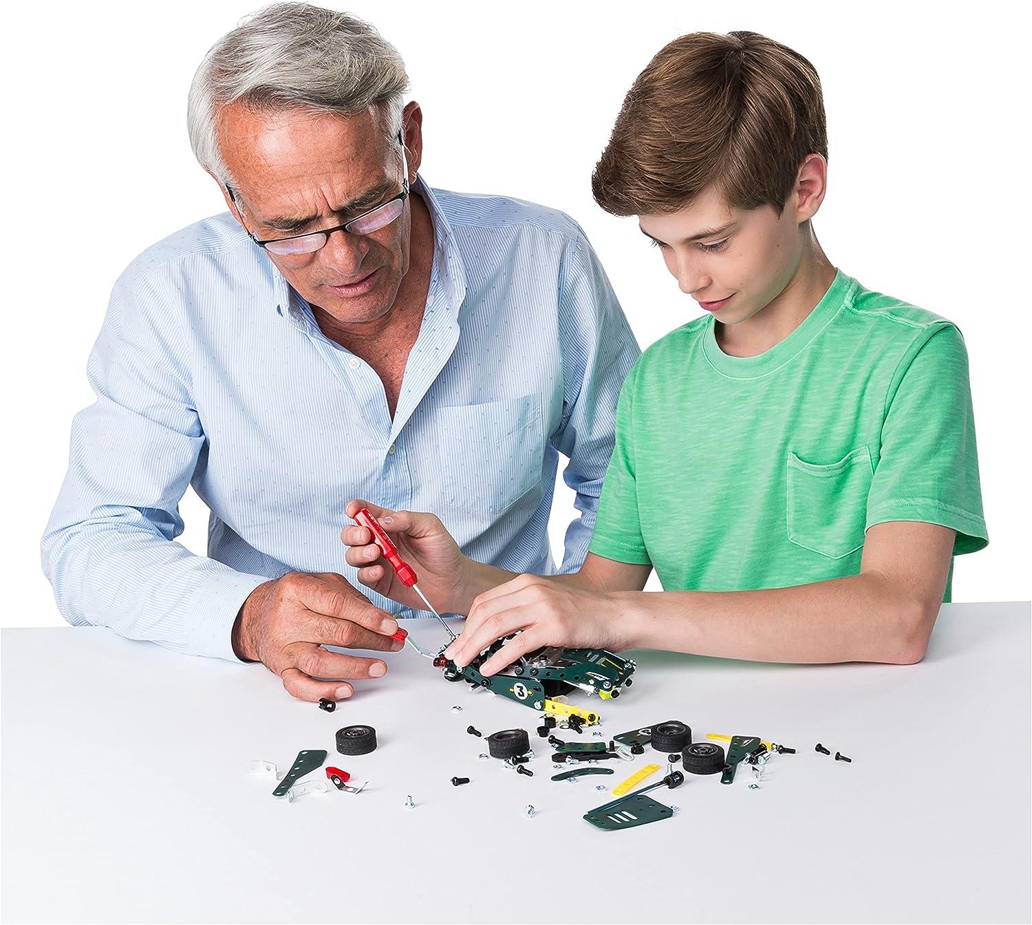 An older man and a boy assemble a green model car together with a screwdriver