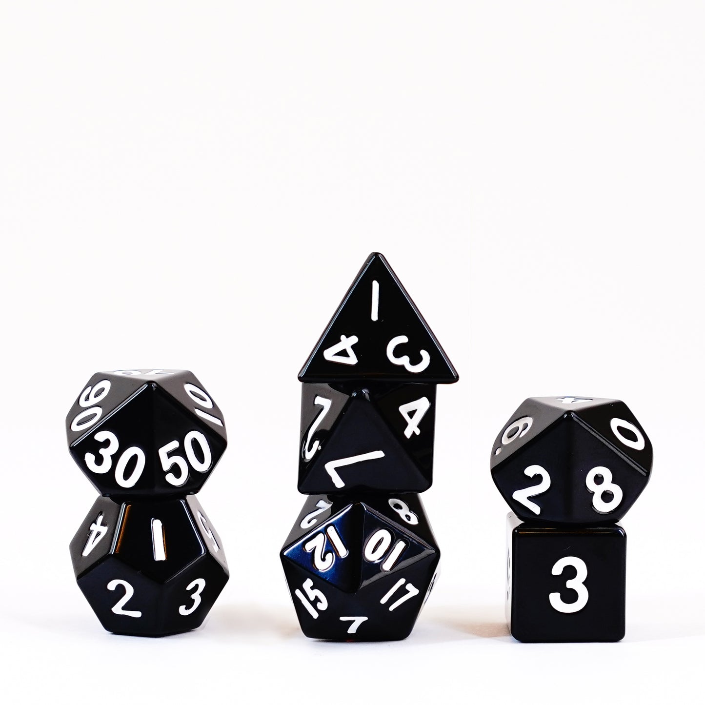 Black metal polyhedral dice set with silver numbering on dark background D20, D12, D10, D8, D6, and D4 shown