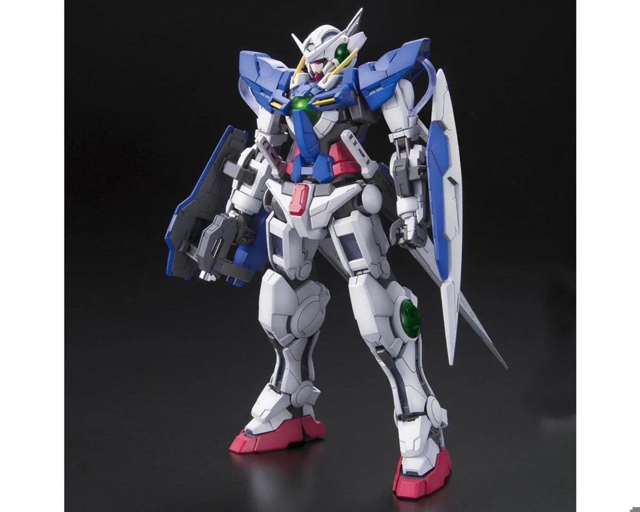 White and blue Gundam model stands holding a rifle and shield on a dark background