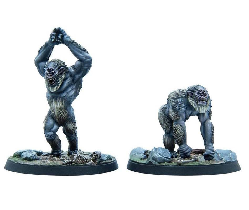 Two grey-blue cyclops monster miniatures. One stands with arms raised over a skeleton, the other crouches.