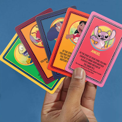 Hand holding five colorful Disney Lilo & Stitch character cards, including Angel, Lilo, Gantu, and Jumba, against a blue background