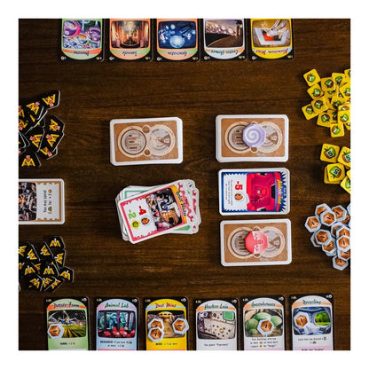 Overhead view of a Moon Colony Bloodbath board game setup with dozens of colorful cards, resource tokens, and stacks on a wood table