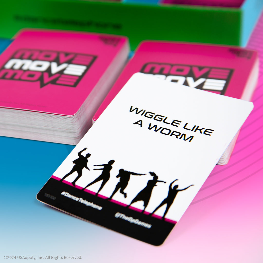 Stacks of vibrant pink Move card game boxes sit on a colorful background with a white Wiggle Like a Worm card front and center showing dancing silhouettes