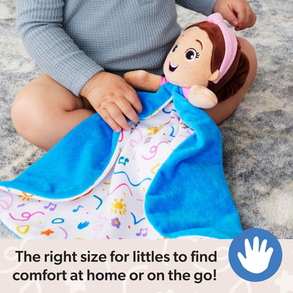 Toddler in a grey top holding a cheerful plush doll with a pink headband and a blue security blanket featuring colorful musical notes and suns, sitting on a soft rug