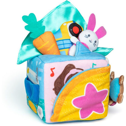 Vibrant soft baby activity cube with plush bunny, carrot, bus, and bear, features a teal satin flap, music notes, and a pink star design