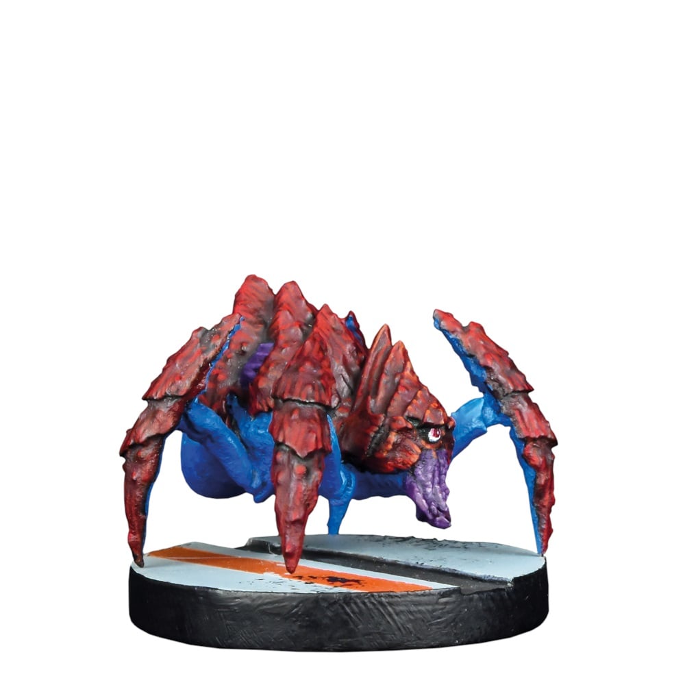 A red and blue spider-like alien miniature with a spiky carapace stands on a textured game base