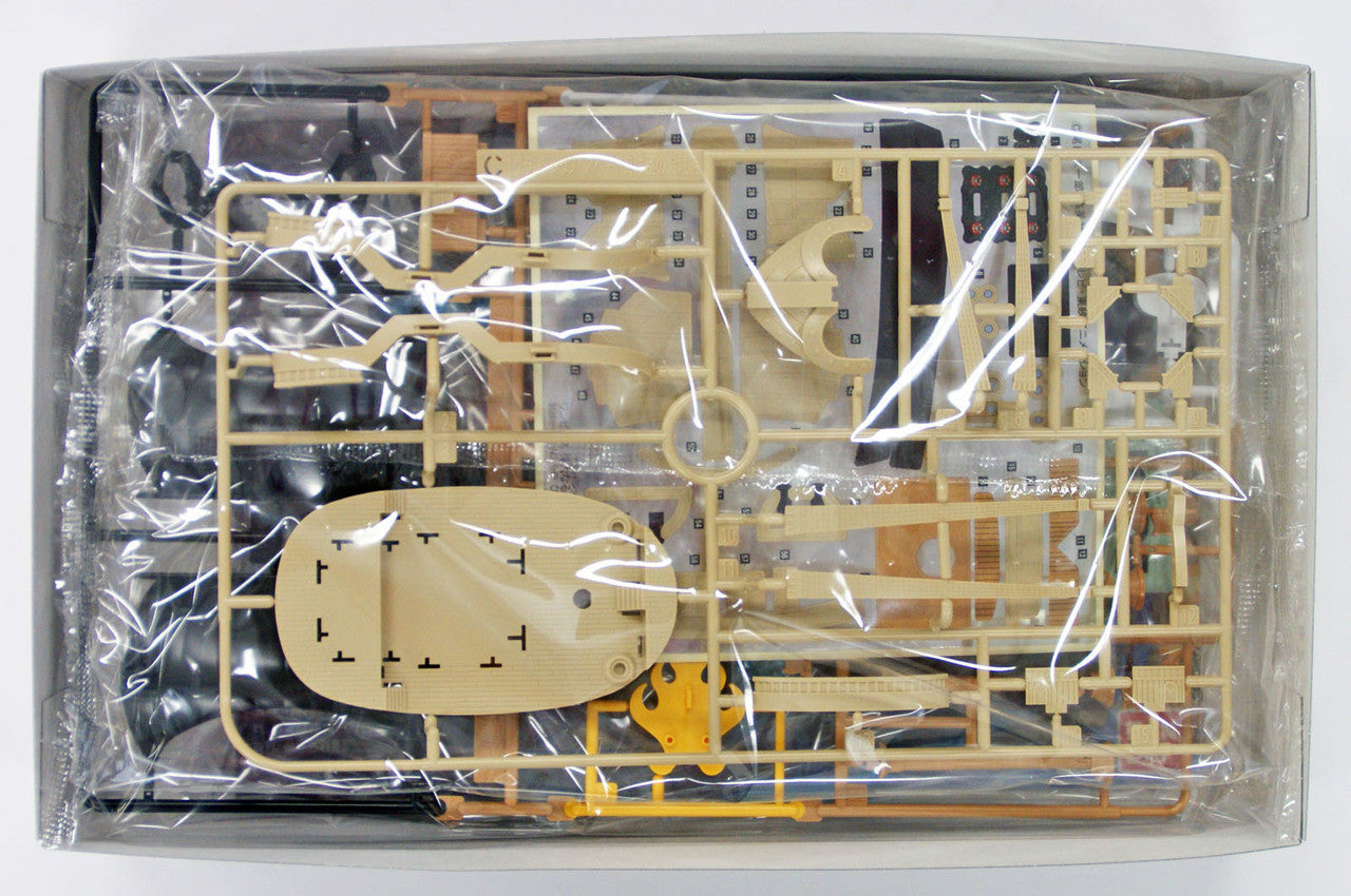Unbuilt plastic model ship kit with tan parts on sprues, sealed in clear plastic inside a box
