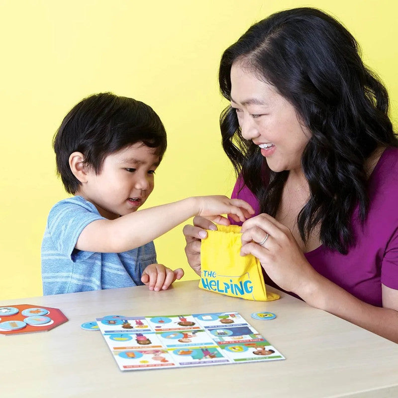 Peaceable Kingdom Friends and Neighbors The Helping Game child reaches into a yellow drawstring bag held by a woman board and tokens visible on a table