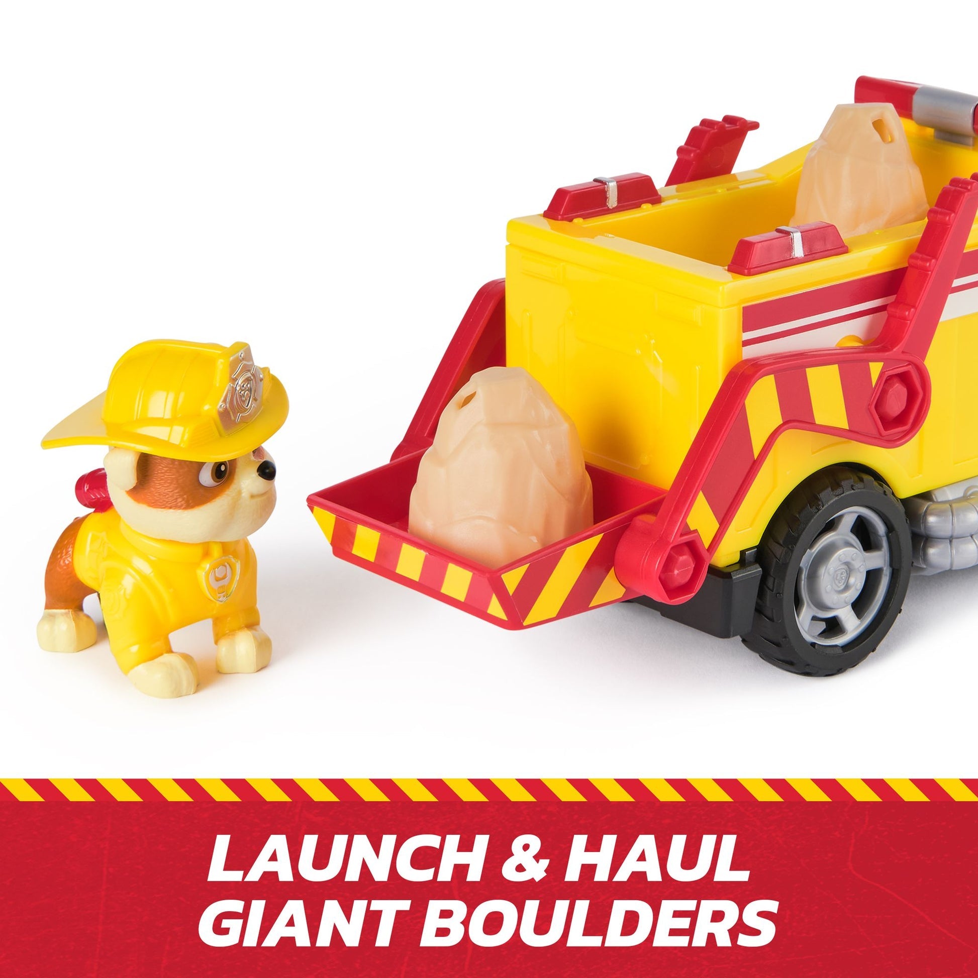 Paw Patrol Rubble toy in yellow suit next to a yellow & red construction truck with boulder launcher and two plastic boulders