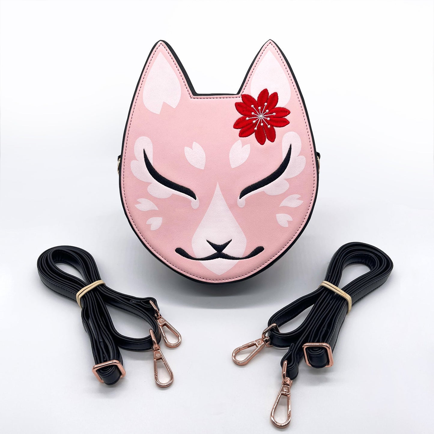 Pink kitsune mask bag with black details, white sakura, red flower, and two black straps.