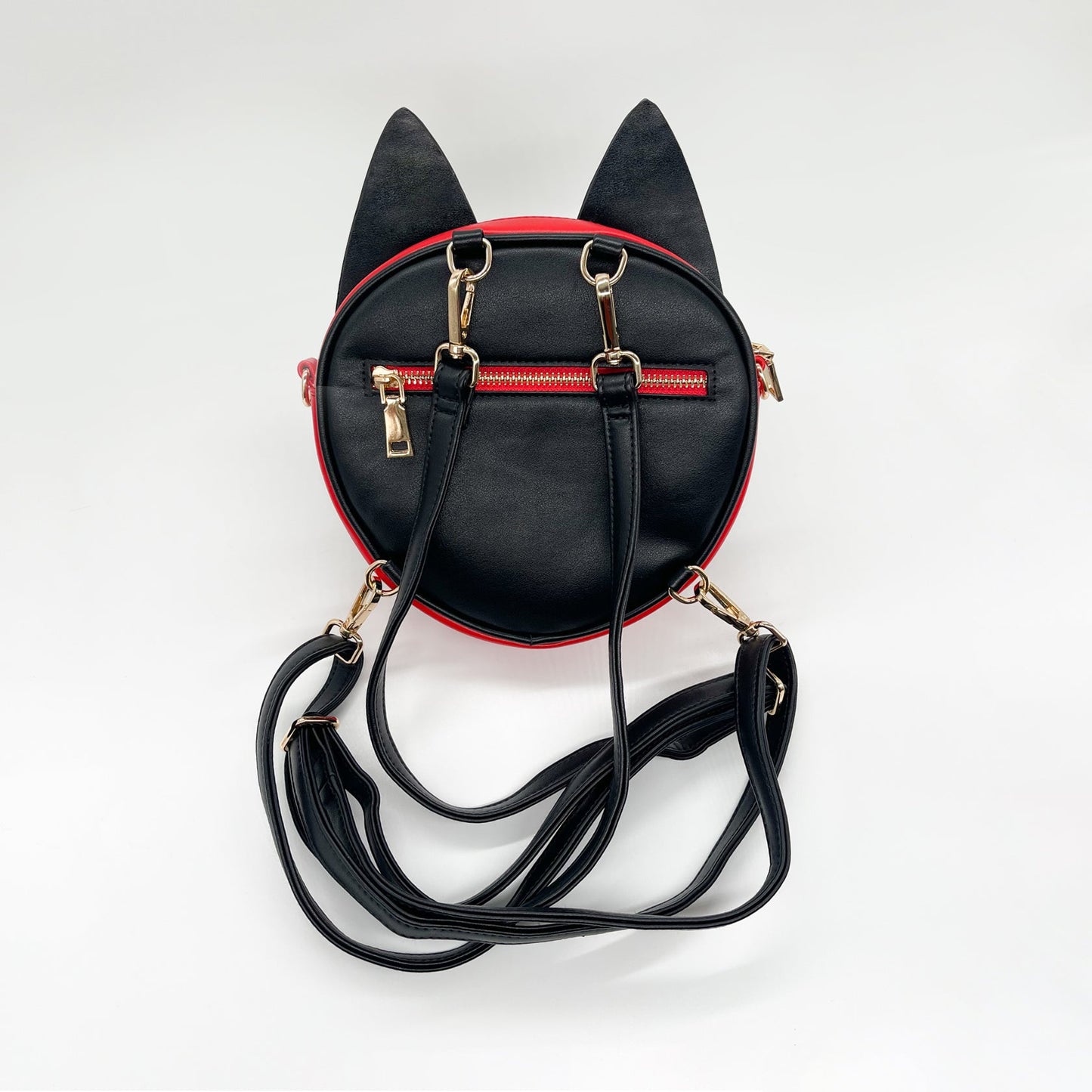 Black and red cat-eared mini backpack with gold zippers and straps, seen from the back on a white background.