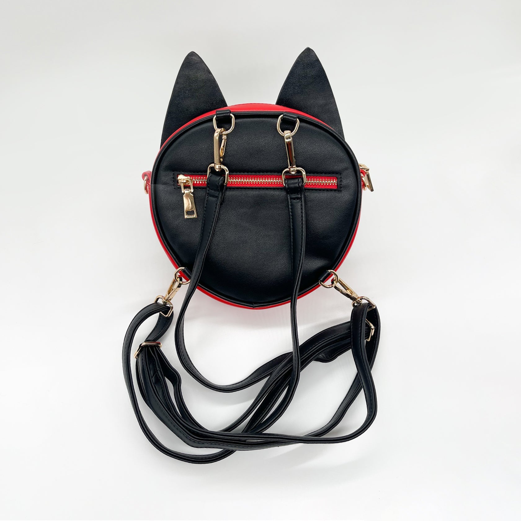 Black and red cat-eared mini backpack with gold zippers and straps, seen from the back on a white background.