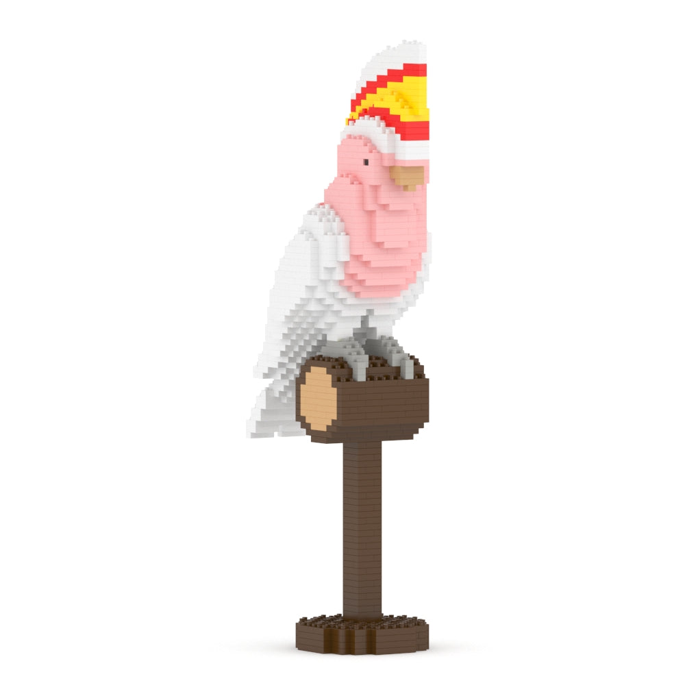 Block-style pink and white cockatoo with a yellow and red crest, perched on a brown stand