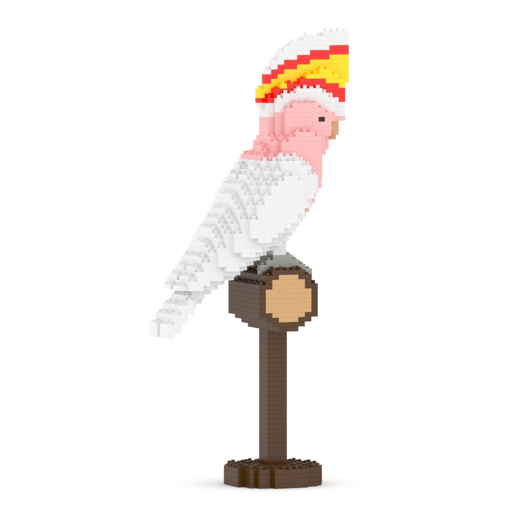 Block-built pink and white cockatoo with a red and yellow crest perching on a brown block stand