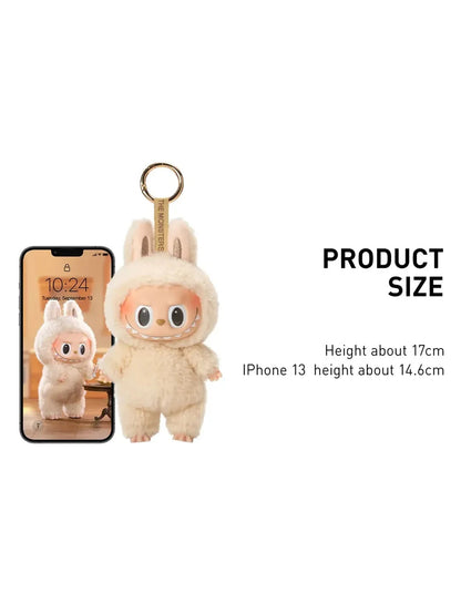 Smiling monster keychain with bunny hood shown next to an iPhone for size comparison