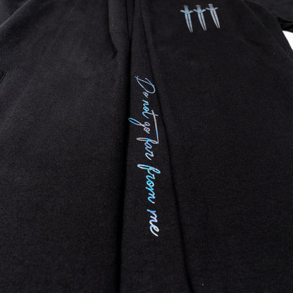Black Vax'ildan hooded cloak with iridescent vertical text "Do not go far from me" and three dagger icons