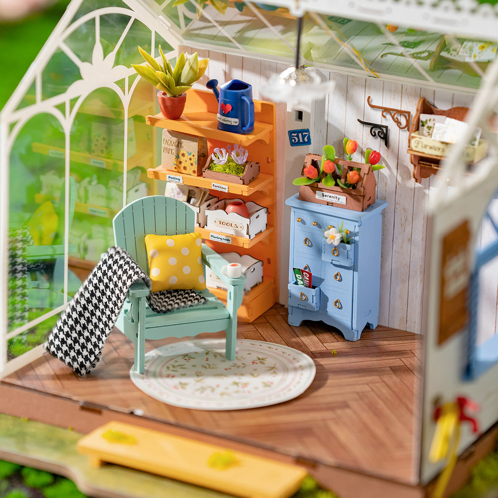 Miniature greenhouse room with a blue Adirondack chair, orange shelving stocked with tiny plants and gardening tools