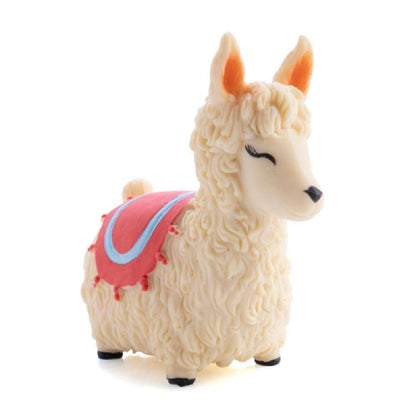 Cream toy llama figurine with sculpted fur and a pink decorative blanket, isolated on white