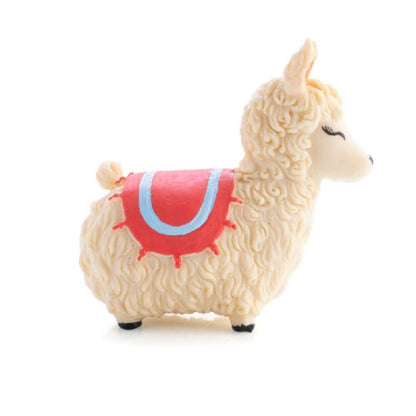 Toy llama figurine with curly beige wool and a red and blue decorative saddle blanket