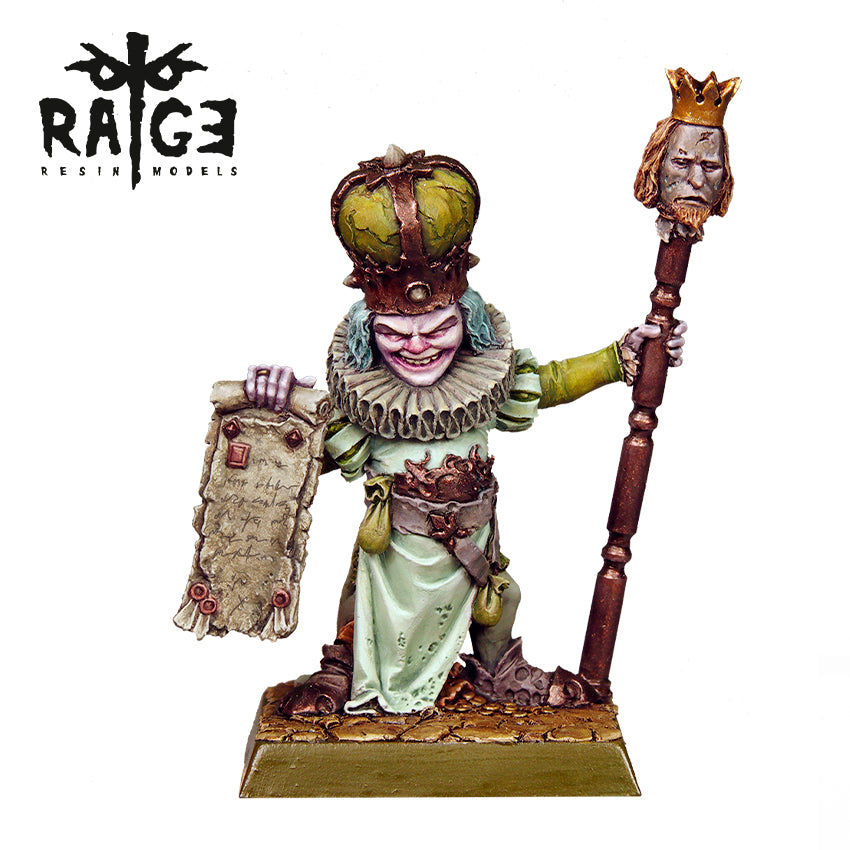 Roggus The Fake King Figure is a grotesque miniature with a large green crown, ruffled collar, a scroll in one hand, and a staff topped with a crowned head in the other