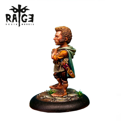 AK Interactive Fantasia Latorre Resins Yarry Light Feet Figure 54mm is a miniature of a male hobbit-like character with curly hair, crossed arms, a green cloak, and bare hairy feet on a rocky base
