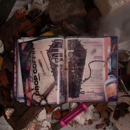 Open book on rubble displays gothic schematics of a spiked coffin, labeled "Prop Coffin," beside an "Emergency Stake"